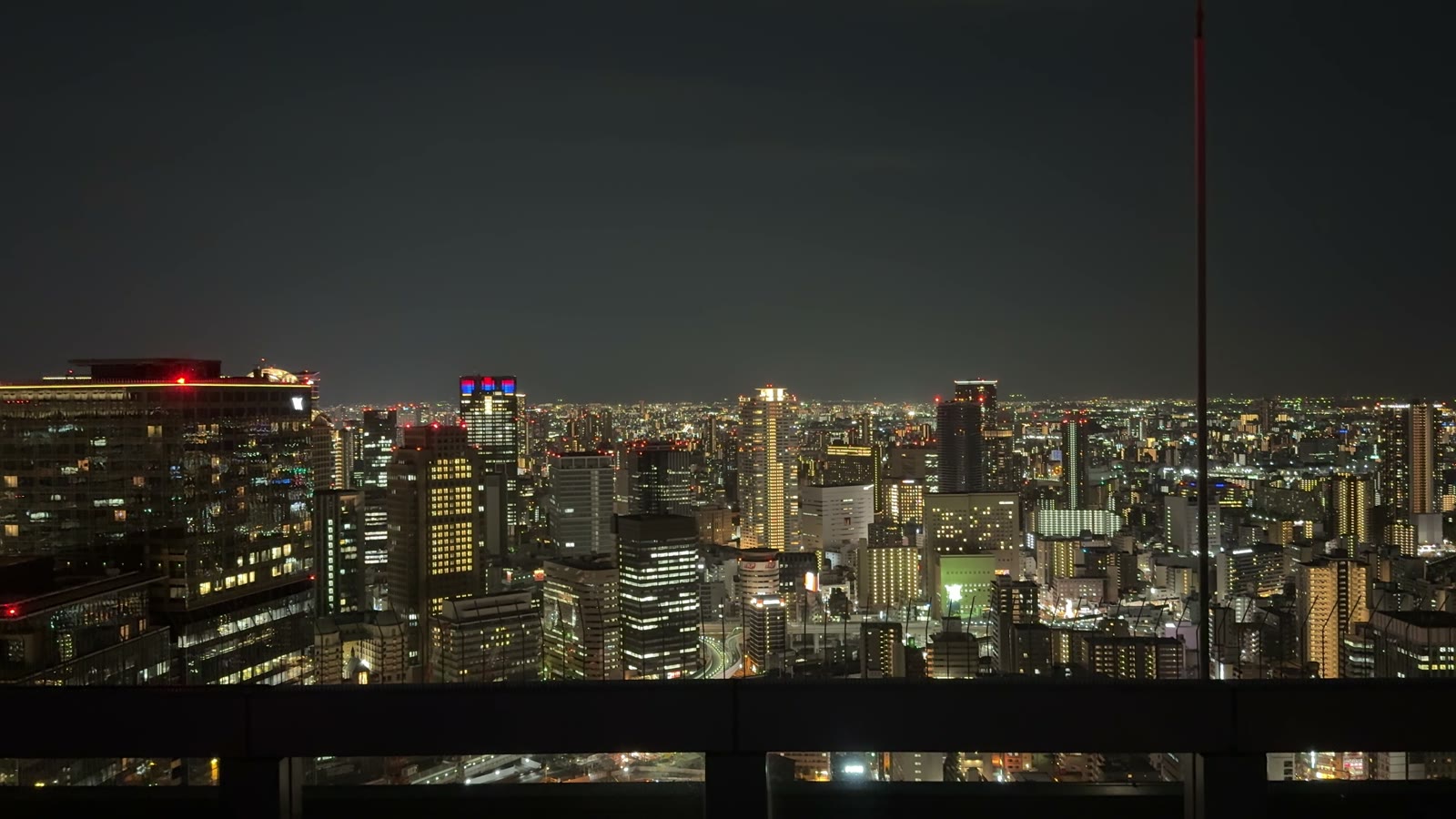 Osaka's night skyline lit up, seen from the open-air Floating Garden Observatory at the Umeda Sky Building